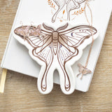 Butterfly-shaped jewelry dish with a necklace on a wooden surface