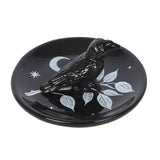 Black ceramic dish with a bird design on a white background