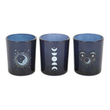 Three blue glass tumblers with celestial designs on a white background