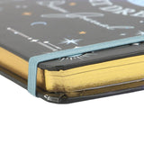 Close-up of a notebook with a gold cover and starry night design on the cover.