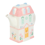 House-shaped teapot with decorative elements on a white background