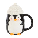 Mug with a penguin design and a white knit cap on a white background