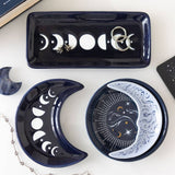 Set of decorative ceramic trays with moon phase designs on a white surface.