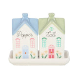 Salt and pepper shakers shaped like houses with a decorative tray on a white background