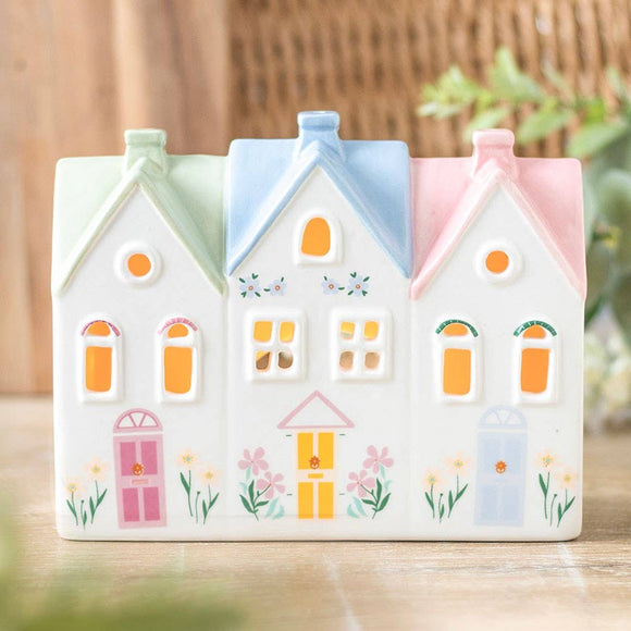 Decorative ceramic houses with pastel colors on a wooden surface