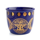 Blue cup with gold pentagram and moon phases design on a white background