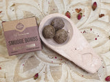 Smudge bombs in a dish with packaging on a decorative surface