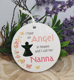 Round white ceramic plaque with text and silhouette of a person, surrounded by flowers.