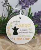 Memorial ornament with text 'We have an Angel in heaven and we call them Our Precious Little One' on a white background with flowers.