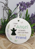 Decorative plaque with angel silhouette and text about an angel in heaven, surrounded by greenery and flowers.