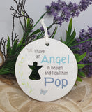Round white plaque with text and silhouette of a person, surrounded by greenery and purple flowers.