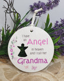Round white plaque with text and silhouette of a person, surrounded by greenery and purple flowers.