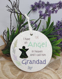 Round ceramic plaque with text 'I have an Angel in heaven and I call him Grandad' on a wooden surface with lavender and greenery.