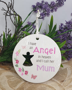 Round ceramic plaque with text 'I have an Angel in heaven and I call him Grandad' on a wooden surface with lavender and greenery.