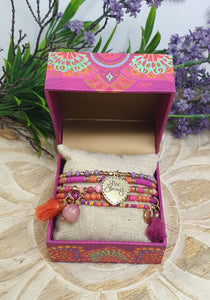 Colorful jewelry set in a decorative box with flowers in the background
