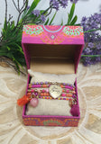 Colorful jewelry set in a decorative box with flowers in the background