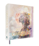 A 2027 Gratitude Diary & Daily Planner by Regan Books, shown at a three-quarter angle. The cover features a double-exposure style portrait of a woman's profile with a glowing moon and celestial elements, overlaid with the text '2027 GRATITUDE' in gold lettering.