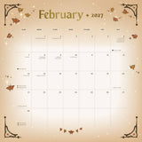 A February 2027 calendar page with a warm beige and cream background, decorated with autumn leaves, stars, and corner flourishes. The title 'February 2027' appears at the top in a gold-toned font, with the days of the week and dates laid out in a grid below.