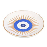 Decorative plate with sunburst design and blue center on a white background