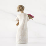 Angel figurine holding flowers on a white background