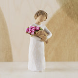 Figurine of a person holding flowers against a neutral background