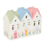 Decorative ceramic house with pastel-colored roofs on a white background