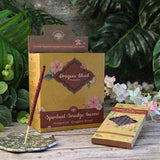 Spiritual smudge incense packaging with incense stick on a wooden surface with plants in the background