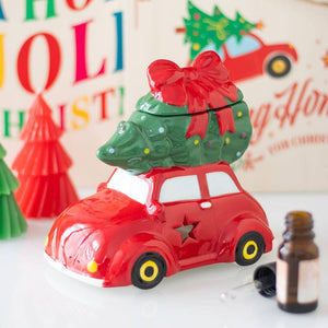 Red car with a green tree on top, set against a festive background with colorful letters and decorations.