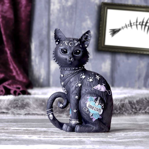 Decorative black cat figurine with star and moon designs on a wooden surface.