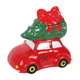Red car with a green Christmas tree and red bow on top against a white background