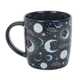 Black mug with celestial design featuring moons, stars, and clouds on a white background