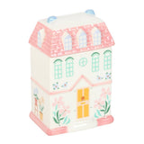 Decorative house-shaped container with pink roof and pastel colors on a white background