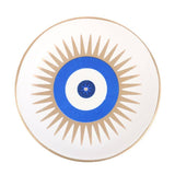 Decorative plate with blue center and gold sunburst pattern on a white background