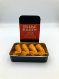 Metallic container with rolled incense and 'Tribe Earth' packaging on a white background