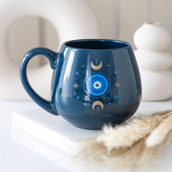 Blue mug with celestial design on a white surface