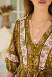 Woman wearing a floral patterned dress with a blurred background