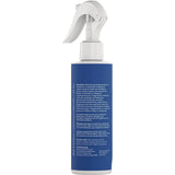 Blue spray bottle with white nozzle on a beige background