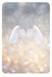 White angel wings on a blurred background with bokeh lights