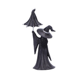 Statue of a witch in black dress and hat on a white background