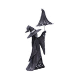 Decorative witch figurine holding an umbrella on a white background