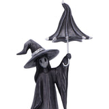 Statue of a ghostly figure in a witch hat holding an umbrella on a white background