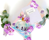 Cosmetic product with purple flowers and a card on a white background