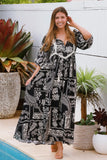 Woman in a black and white patterned dress standing by a pool with plants around.
