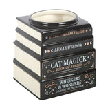 Decorative candle holder shaped like stacked books with text on a white background