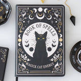 Book titled 'Book of Spells: Magick Cat Energy' with a black cat illustration on a white surface.