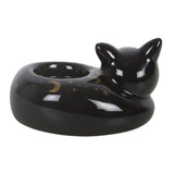 Black ceramic cat-shaped dish with star and moon designs on a white background