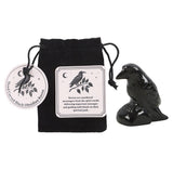 Black obsidian raven figurine with packaging and label on a white background