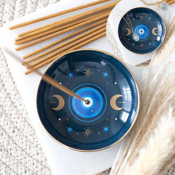 Two blue ceramic incense holders with star and moon designs on a textured surface.
