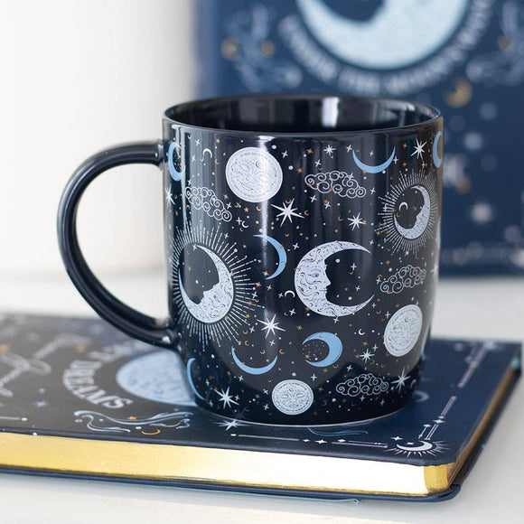 Black mug with celestial design on a book