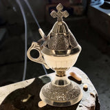 Decorative silver incense burner on a stone surface